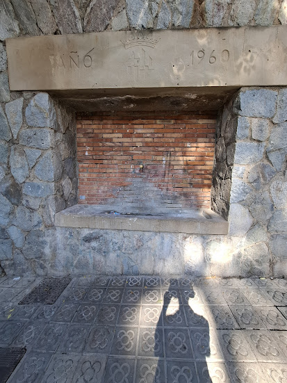 Shadow selfie with fountain and cement flowers.